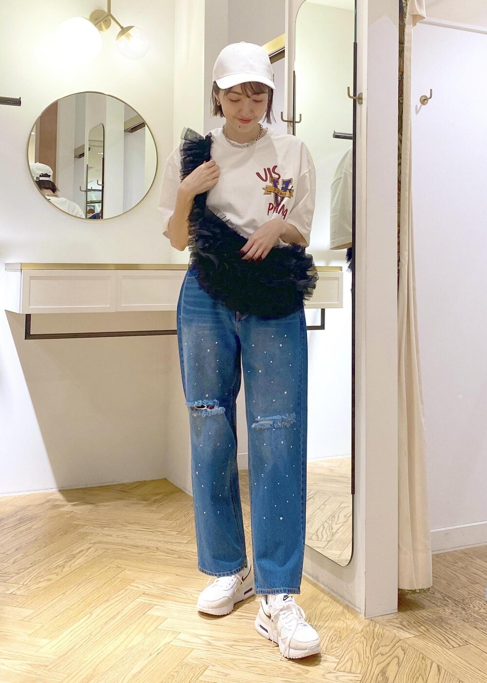 ブルー系のデニムパンツ、ブラック系のショルダーバッグ、ホワイト系のTシャツ/カットソーを着用したレディースの春コーディネートの4枚目の写真