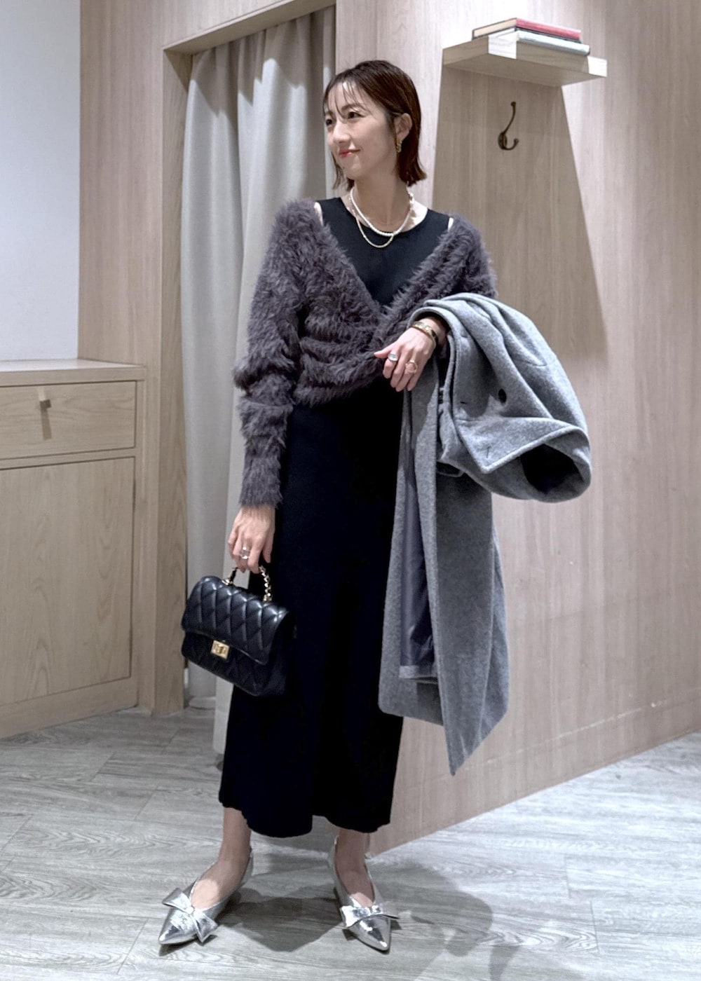 シルバー系のパンプス、グレー系のその他アウター、グレー系のワンピースを着用したレディースの冬コーディネートの10枚目の写真