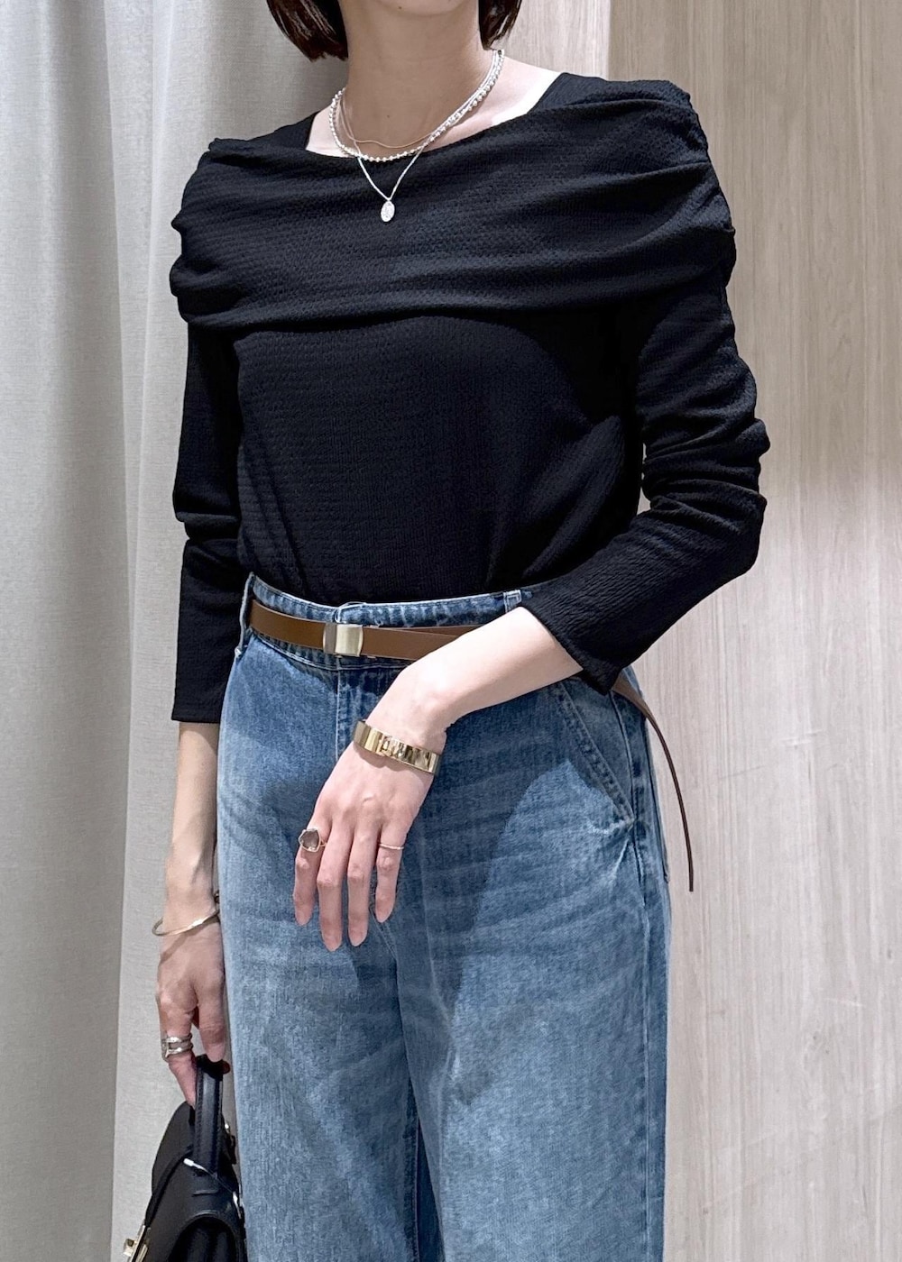 ブラック系のショルダーバッグ、ブルー系のデニムパンツ、ブラック系のTシャツ/カットソーを着用したレディースの春コーディネートの9枚目の写真