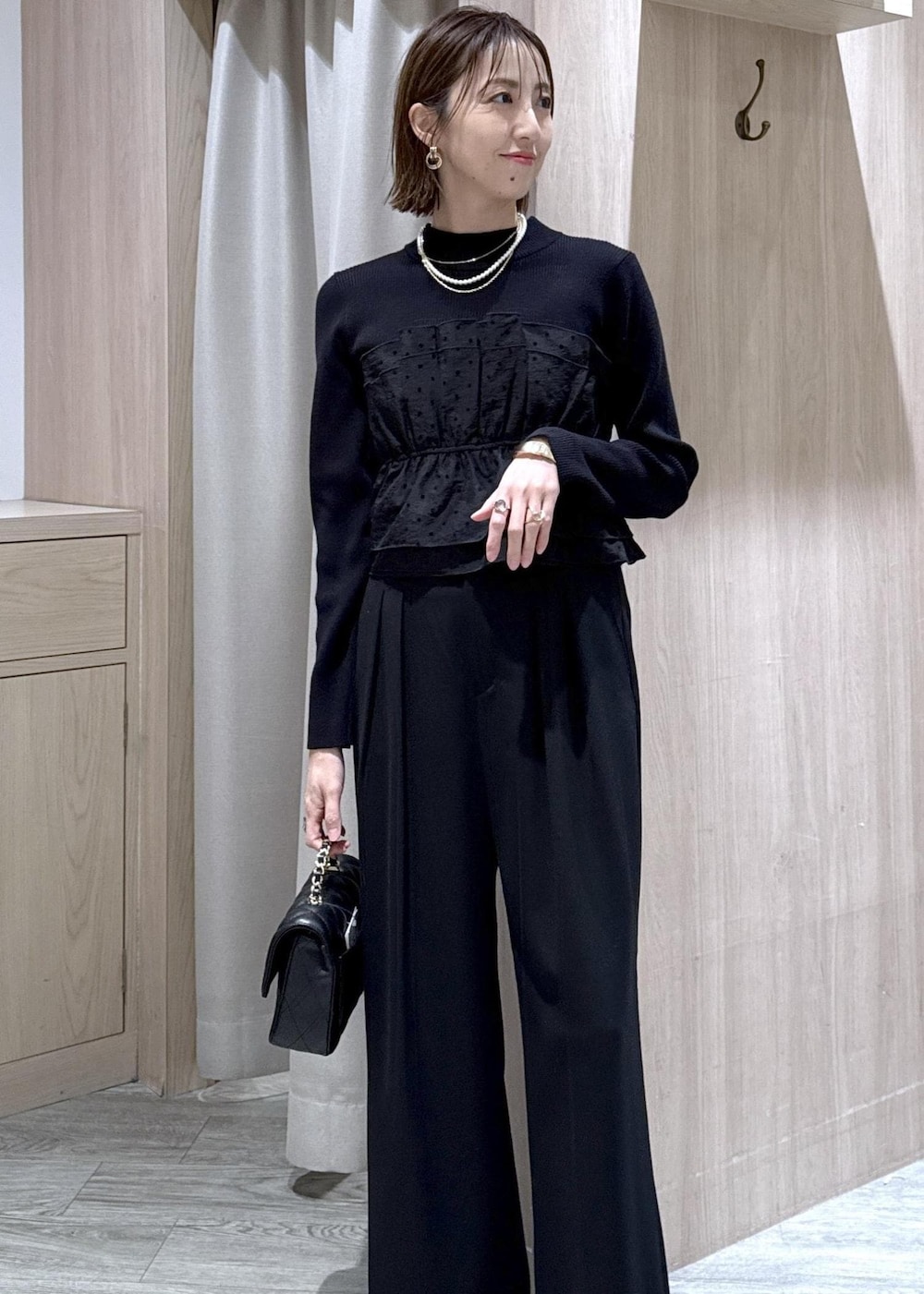 ブラック系のその他パンツ、ブラック系のニット/セーター、ブラック系のショルダーバッグを着用したレディースの冬コーディネートの3枚目の写真