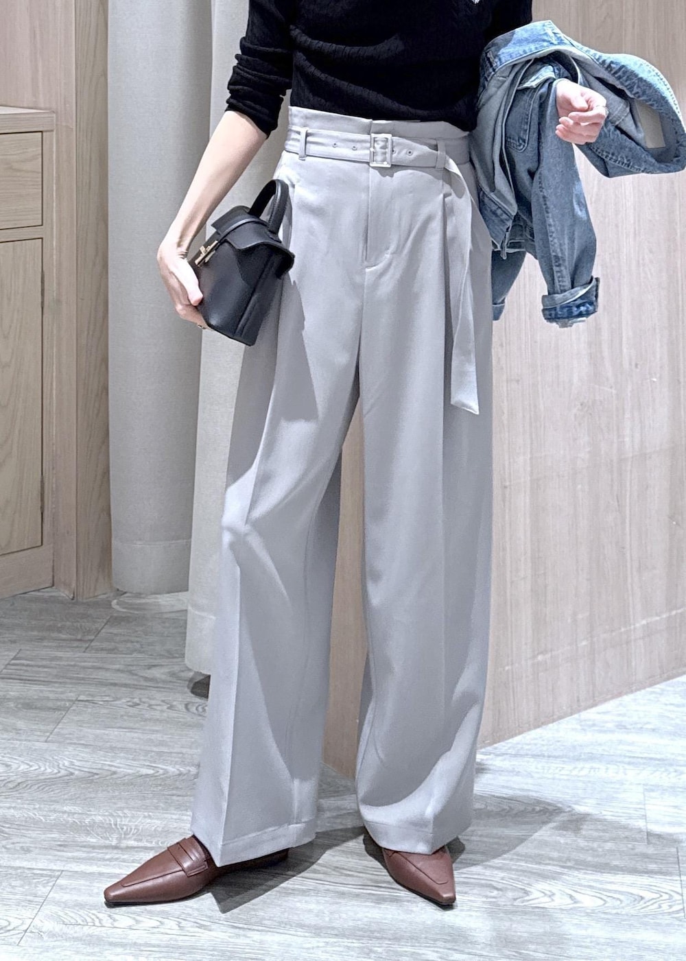 ブラック系のショルダーバッグ、ブルー系のデニムジャケット、グレー系のスラックスを着用したレディースの春コーディネートの8枚目の写真