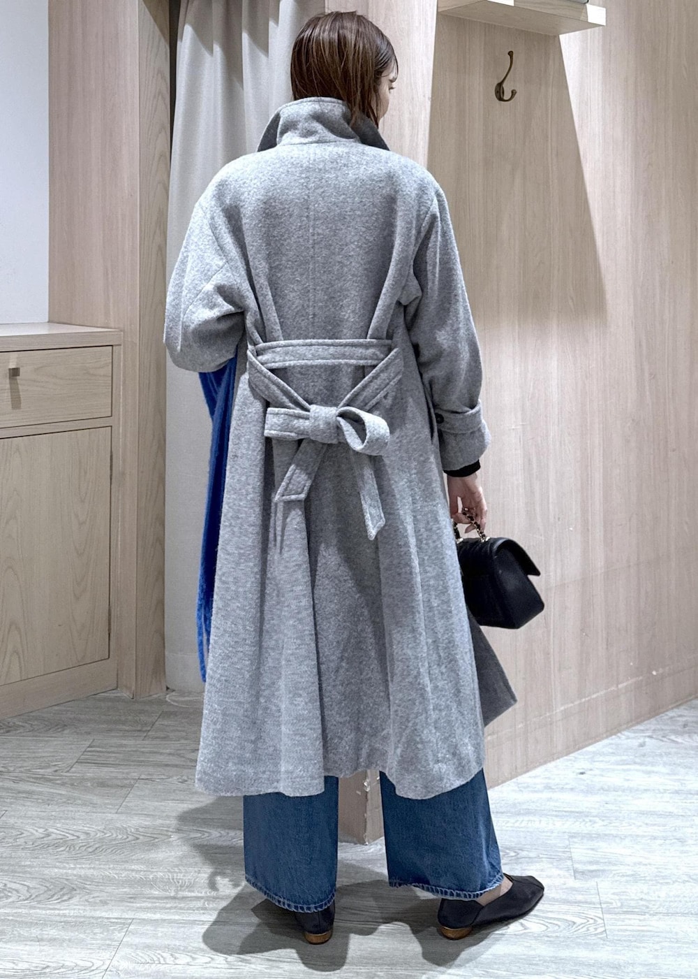 グレー系のその他アウター、ブルー系のデニムパンツ、ブラック系のニット/セーターを着用したレディースの冬コーディネートの2枚目の写真