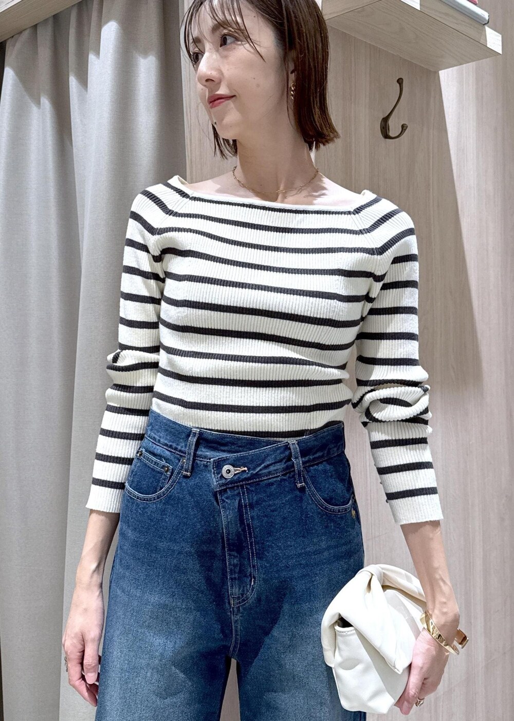 ブルー系のデニムパンツ、グレー系のテーラードジャケット、ホワイト系のショルダーバッグを着用したレディースの冬コーディネートの9枚目の写真