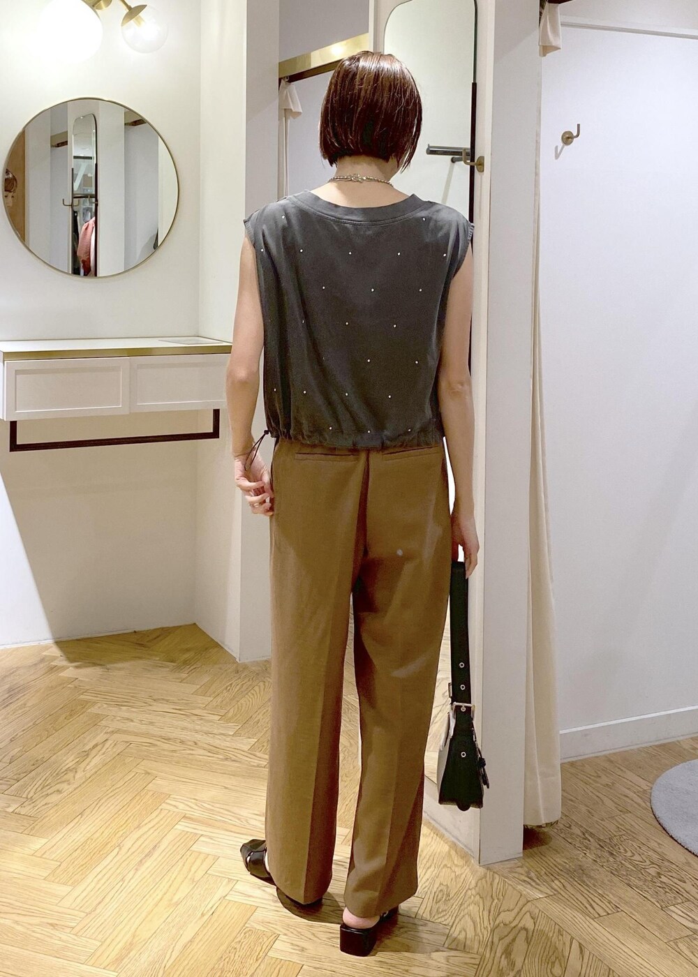 ブラック系のキャミソール、ブラック系のサンダル、ブラック系のショルダーバッグを着用したレディースの夏コーディネートの3枚目の写真