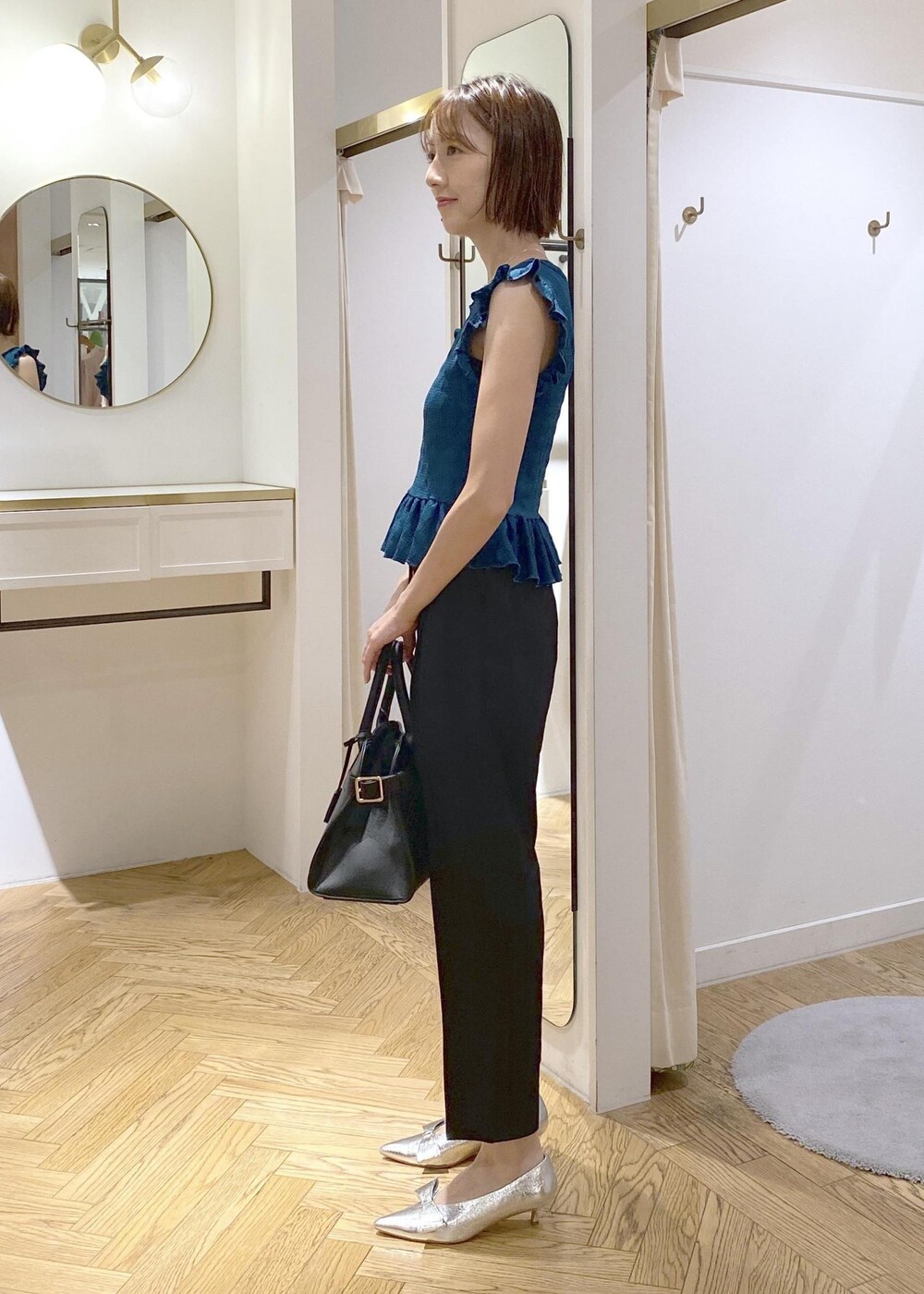 シルバー系のパンプス、ブラック系のスラックス、ブラック系のキャミソールを着用したレディースの夏コーディネートの4枚目の写真