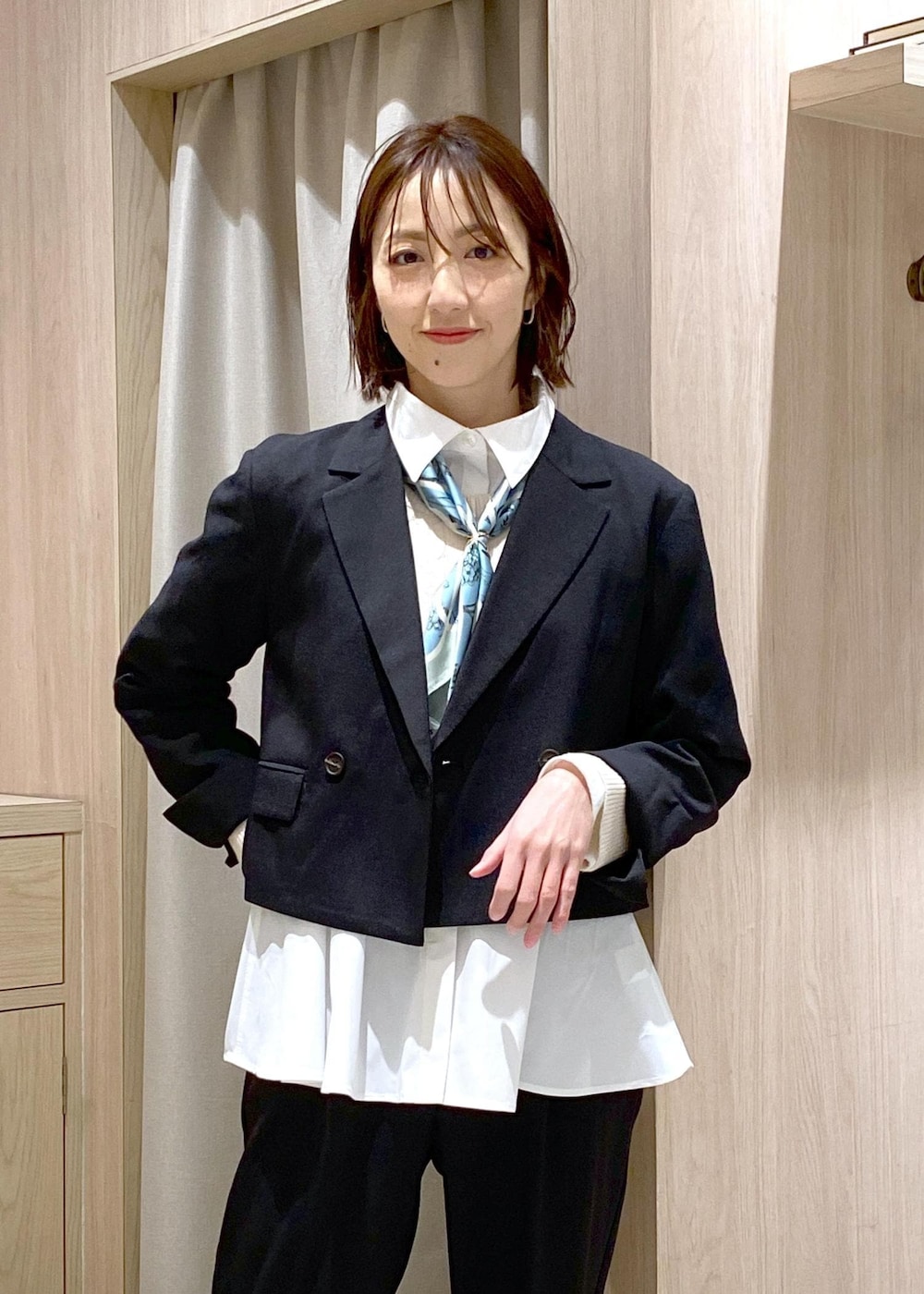 ブラック系のパンプス、ホワイト系のカーディガン/ボレロ、ブラック系のハンドバッグを着用したレディースの冬コーディネートの5枚目の写真