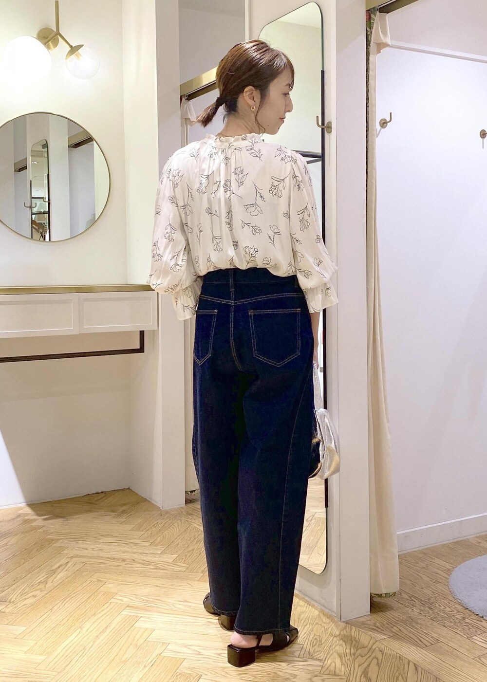 ホワイト系のシャツ/ブラウス、シルバー系のハンドバッグ、ブラック系のサンダルを着用したレディースの春コーディネートの2枚目の写真