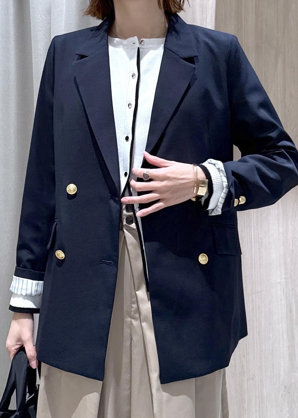 ブルー系のテーラードジャケット、ブラック系のトートバッグ、ホワイト系のカーディガン/ボレロを着用したレディースの冬コーディネートの4枚目の写真