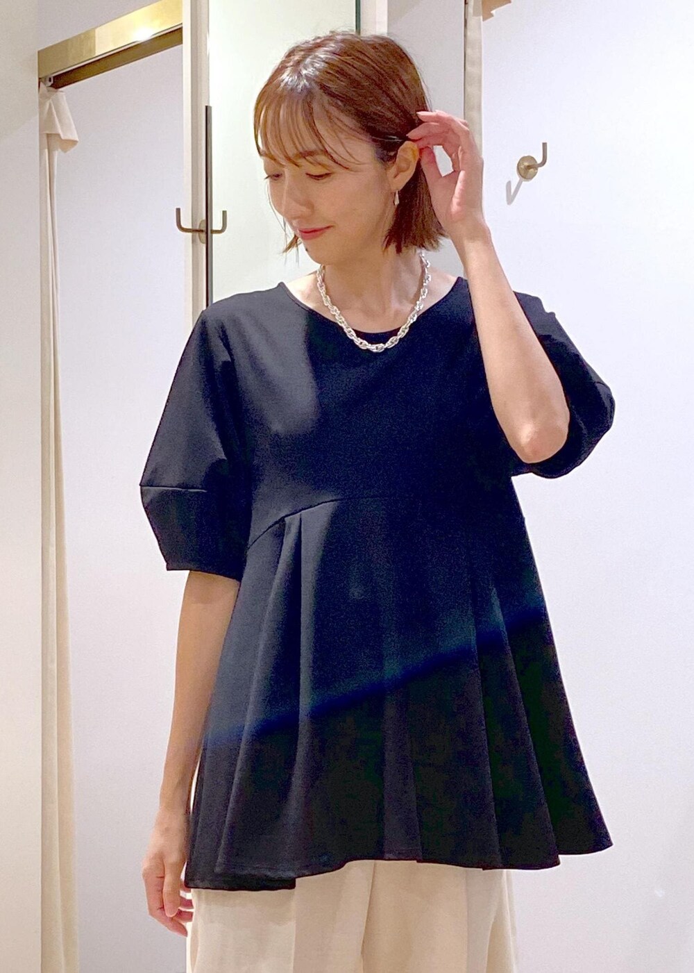 ホワイト系のショルダーバッグ、ホワイト系のスラックス、ブラック系のバレエシューズを着用したレディースの秋コーディネートの6枚目の写真