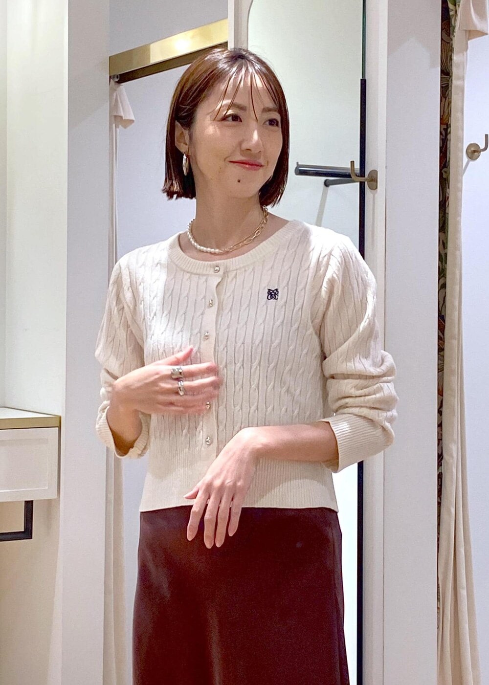 ブラック系のテーラードジャケット、ブラック系のパンプス、ブラウン系のスカートを着用したレディースの冬コーディネートの9枚目の写真