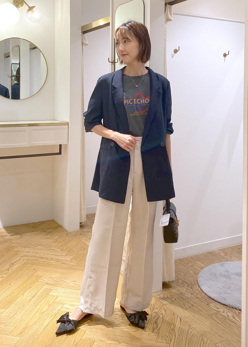 ブルー系のテーラードジャケット、ホワイト系のスラックス、その他のショルダーバッグを着用したレディースの夏コーディネートの5枚目の写真