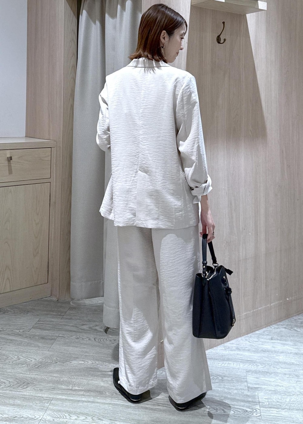 ブラック系のショルダーバッグ、ブラック系のパンプス、ホワイト系のシャツ/ブラウスを着用したレディースの春コーディネートの2枚目の写真