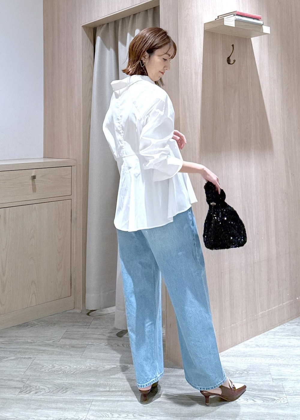 ブラウン系のパンプス、ホワイト系のシャツ/ブラウス、ブルー系のデニムパンツを着用したレディースの春コーディネートの3枚目の写真