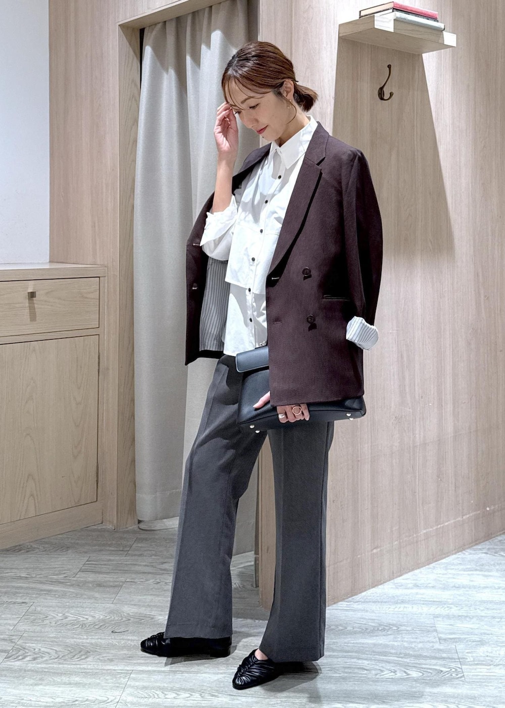 ブラック系のハンドバッグ、ブラック系のパンプス、ホワイト系のシャツ/ブラウスを着用したレディースの秋コーディネートの2枚目の写真