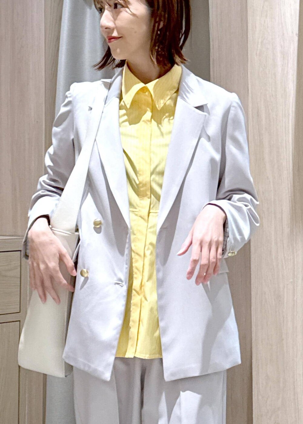 ブラウン系のパンプス、イエロー系のシャツ/ブラウス、ベージュ系のスラックスを着用したレディースの春コーディネートの6枚目の写真