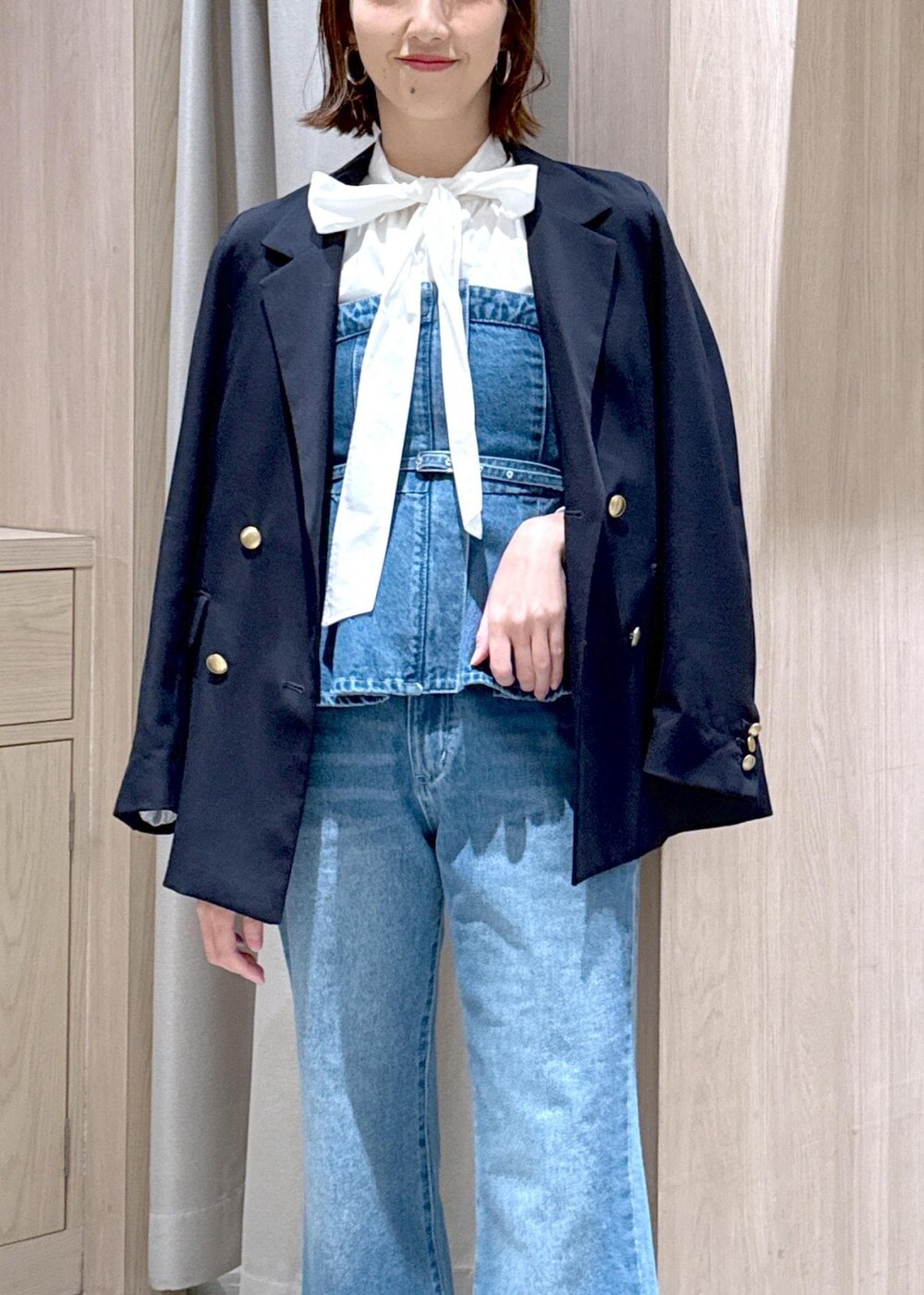 ブラック系のショルダーバッグ、ブルー系のキャミソール、ブルー系のテーラードジャケットを着用したレディースの冬コーディネートの6枚目の写真