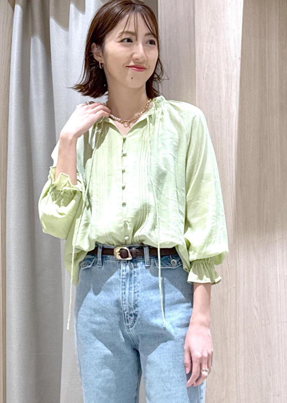 ブルー系のデニムパンツ、ブラウン系のパンプス、ブラック系のハンドバッグを着用したレディースの春コーディネートの8枚目の写真