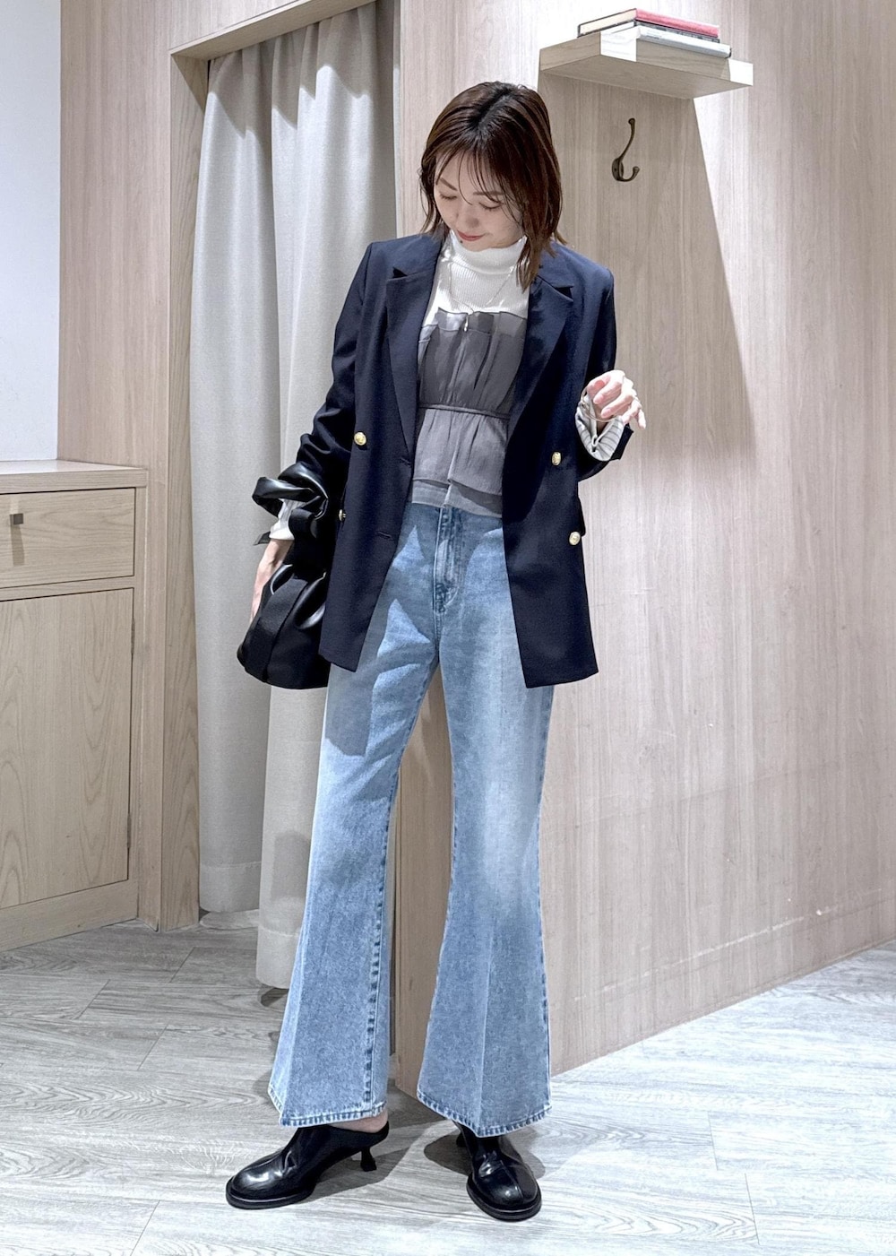 ホワイト系のニット/セーター、ブルー系のテーラードジャケット、ブルー系のデニムパンツを着用したレディースの冬コーディネートの2枚目の写真