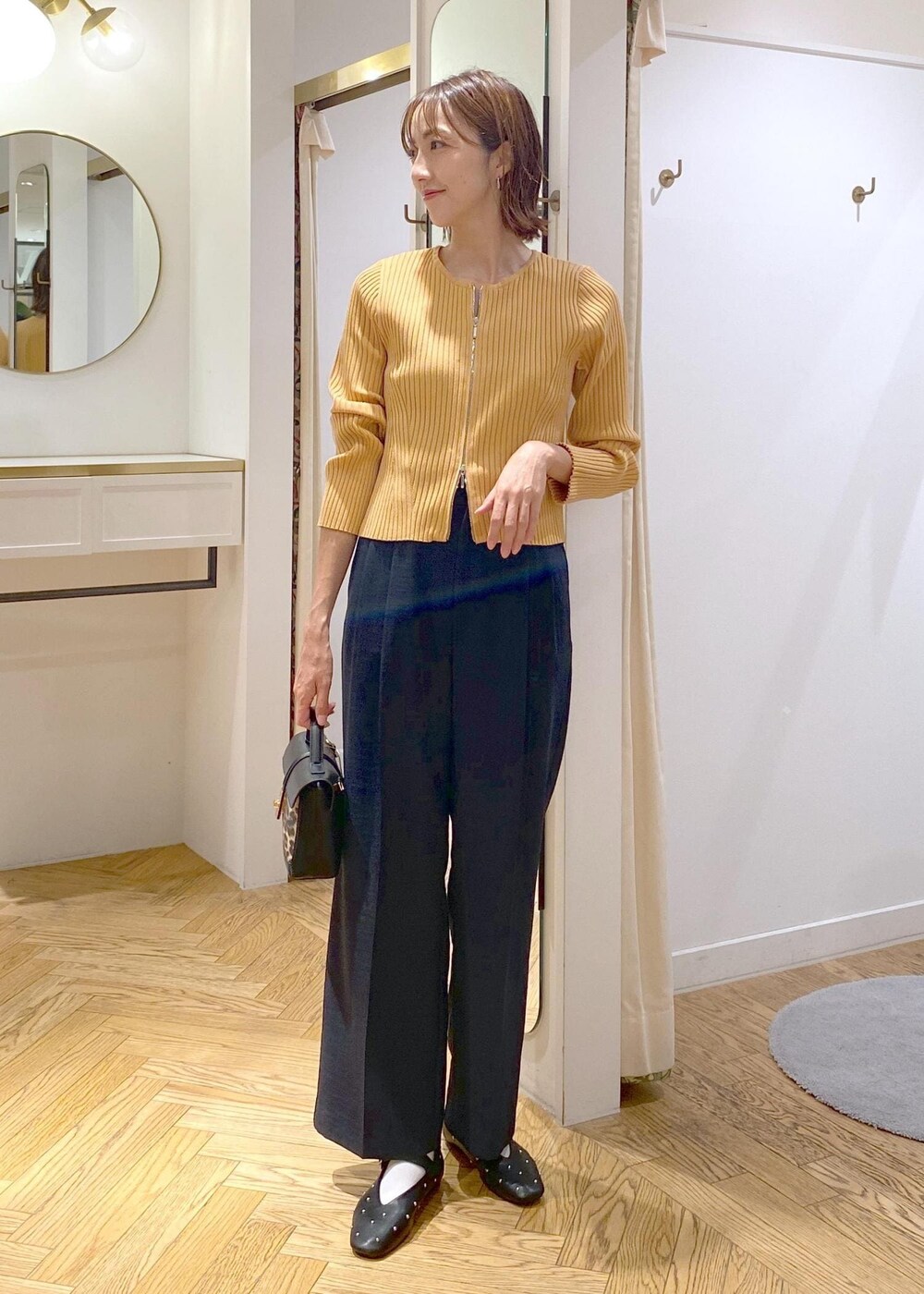 ブルー系のスラックス、その他のショルダーバッグ、ブラック系のバレエシューズを着用したレディースの秋コーディネートの6枚目の写真