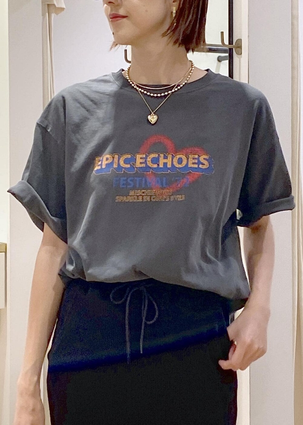 ブラック系のショルダーバッグ、ブラック系のスカート、グレー系のTシャツ/カットソーを着用したレディースの夏コーディネートの7枚目の写真