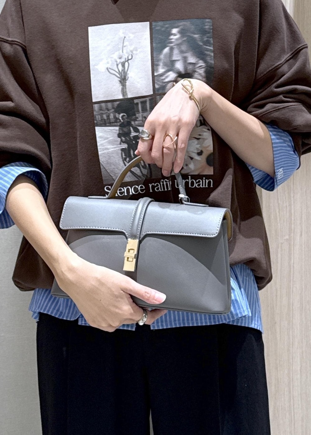 グレー系のショルダーバッグ、ブラック系のスラックス、ブルー系のシャツ/ブラウスを着用したレディースの秋コーディネートの9枚目の写真