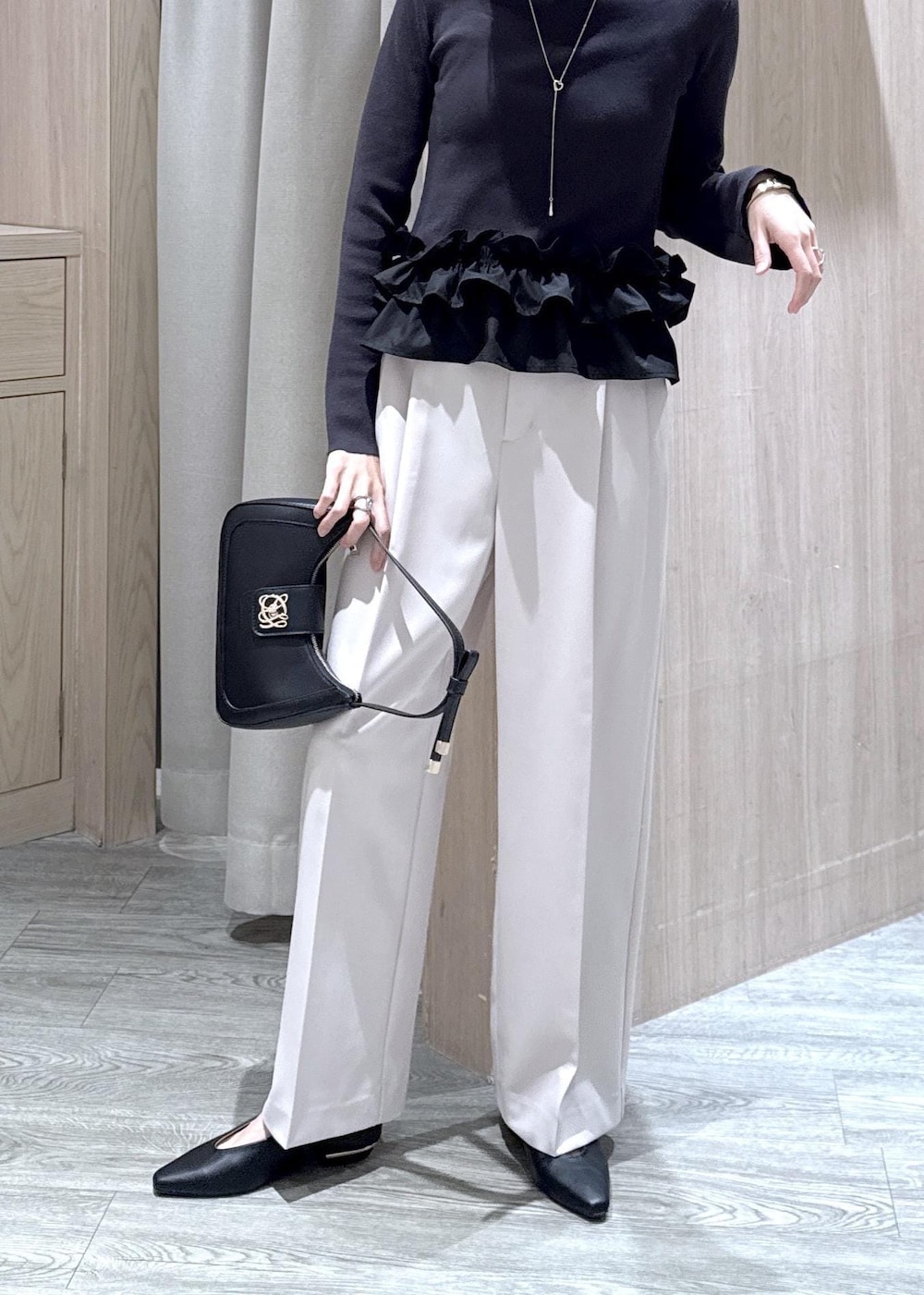 ブラック系のショルダーバッグ、ブラック系のパンプス、グレー系のニット/セーターを着用したレディースの春コーディネートの8枚目の写真