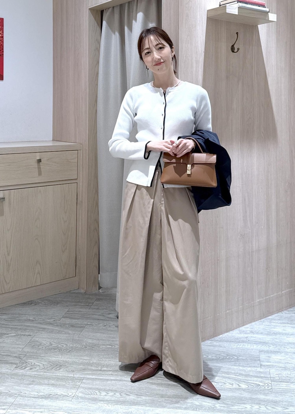 イエロー系のショルダーバッグ、ホワイト系のカーディガン/ボレロ、ベージュ系のその他パンツを着用したレディースの春コーディネートの9枚目の写真