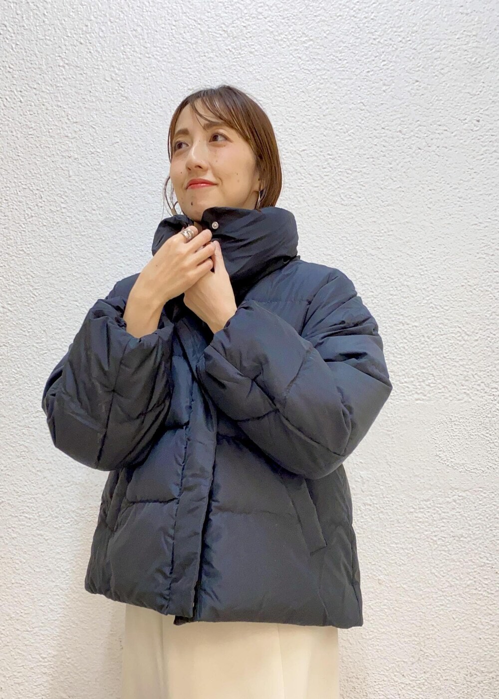 ブラック系のダウンジャケット/コート、ブラック系のブーツ、グレー系のニット/セーターを着用したレディースの冬コーディネートの4枚目の写真