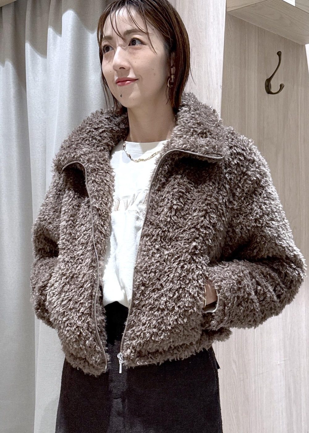 ブラウン系のスカート、ブラウン系のブルゾン、ホワイト系のスウェットを着用したレディースの秋コーディネートの7枚目の写真