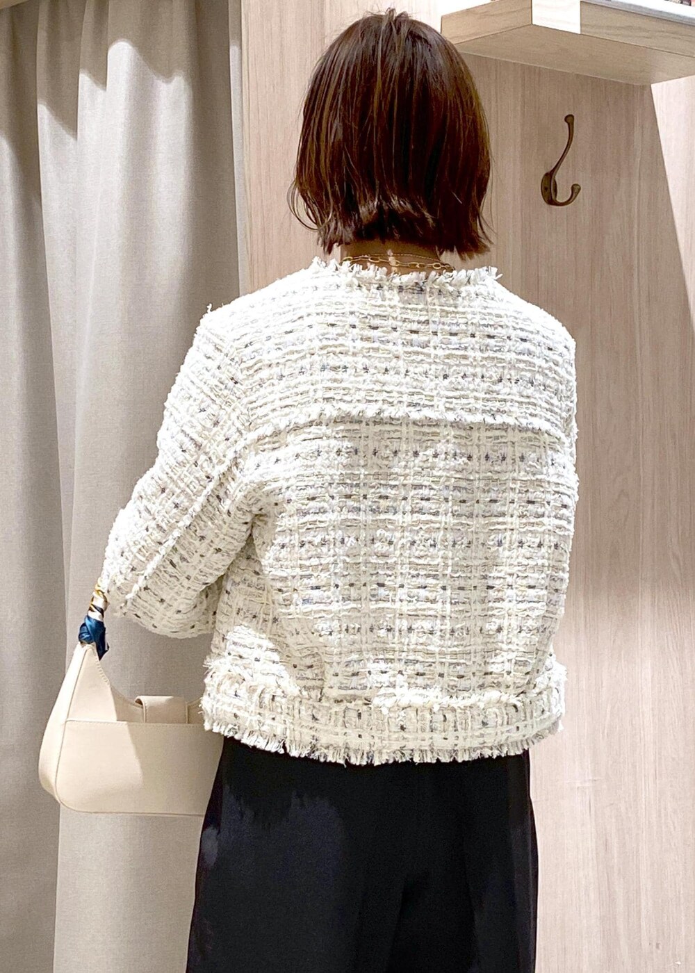 ホワイト系のハンドバッグ、シルバー系のパンプス、ブラック系のTシャツ/カットソーを着用したレディースの冬コーディネートの8枚目の写真