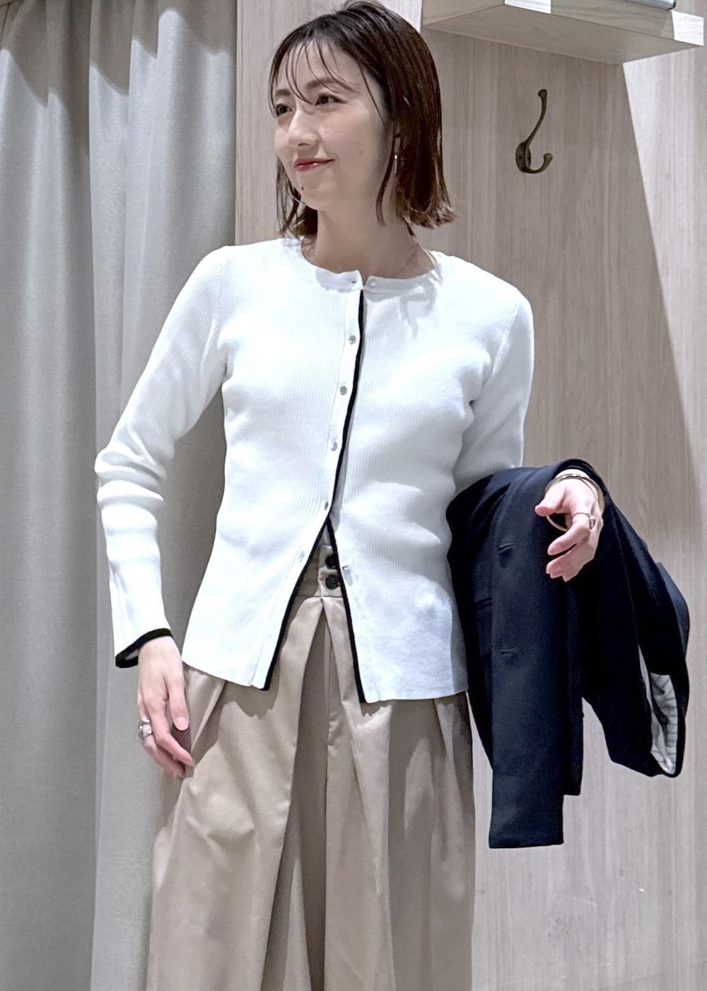 ブルー系のテーラードジャケット、ブラック系のトートバッグ、ホワイト系のカーディガン/ボレロを着用したレディースの冬コーディネートの7枚目の写真