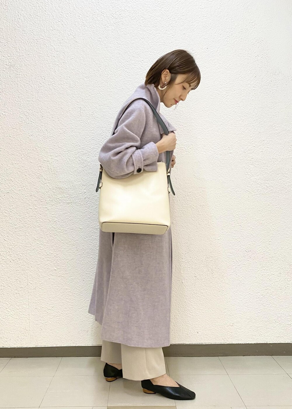 パープル系のその他アウター、ブラック系のシャツ/ブラウス、グレー系のスラックスを着用したレディースの冬コーディネートの2枚目の写真