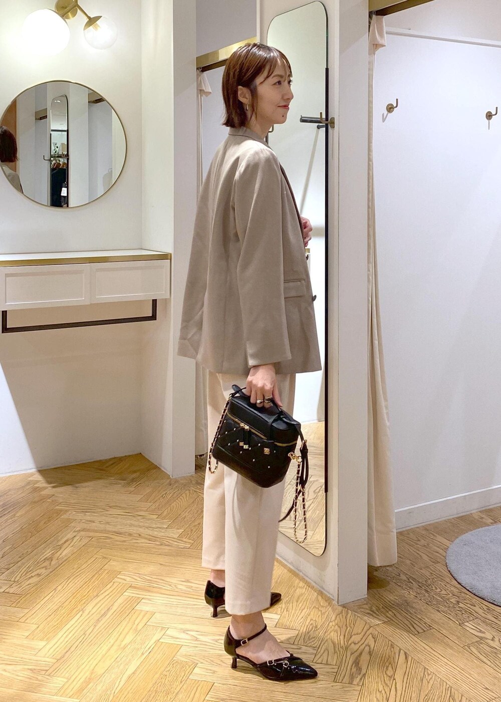 ブラック系のパンプス、ホワイト系のシャツ/ブラウス、ベージュ系のその他パンツを着用したレディースの冬コーディネートの4枚目の写真