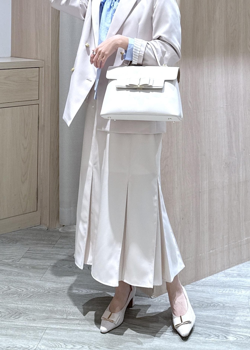 ベージュ系のパンプス、ベージュ系のテーラードジャケット、ブルー系のシャツ/ブラウスを着用したレディースの冬コーディネートの8枚目の写真