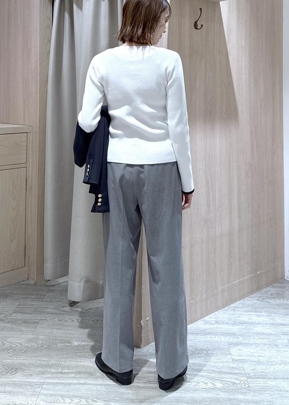 グレー系のその他パンツ、ブルー系のテーラードジャケット、ブラック系のハンドバッグを着用したレディースの冬コーディネートの6枚目の写真