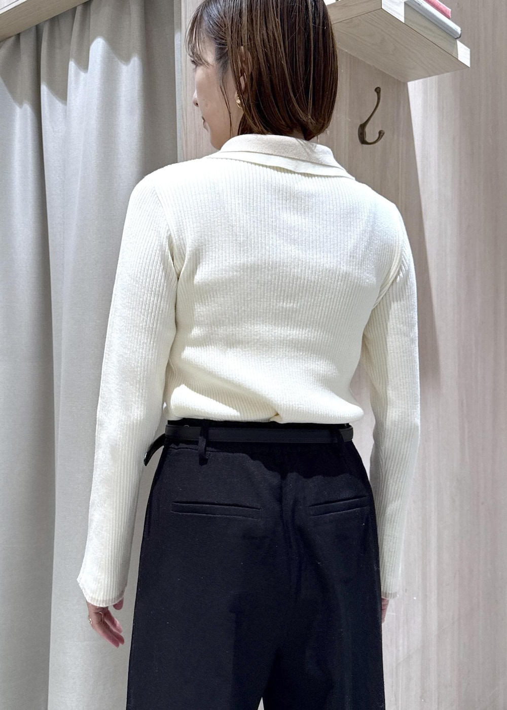 ホワイト系のニット/セーター、グレー系のその他アウター、ブラック系のスラックスを着用したレディースの冬コーディネートの8枚目の写真