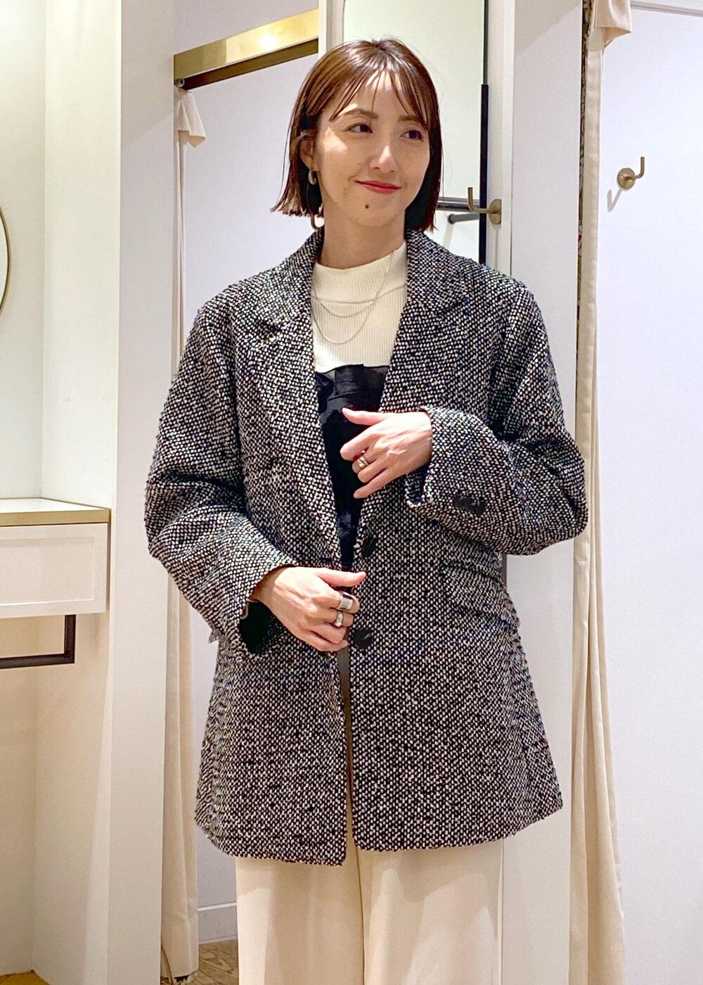 ブラック系のパンプス、ホワイト系のニット/セーター、ホワイト系のスラックスを着用したレディースの冬コーディネートの4枚目の写真