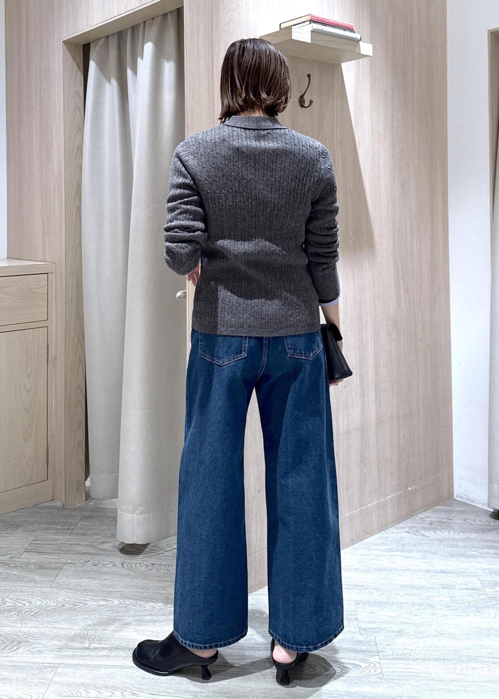 ブラック系のショルダーバッグ、ブルー系のデニムパンツ、グレー系のブルゾンを着用したレディースの冬コーディネートの7枚目の写真