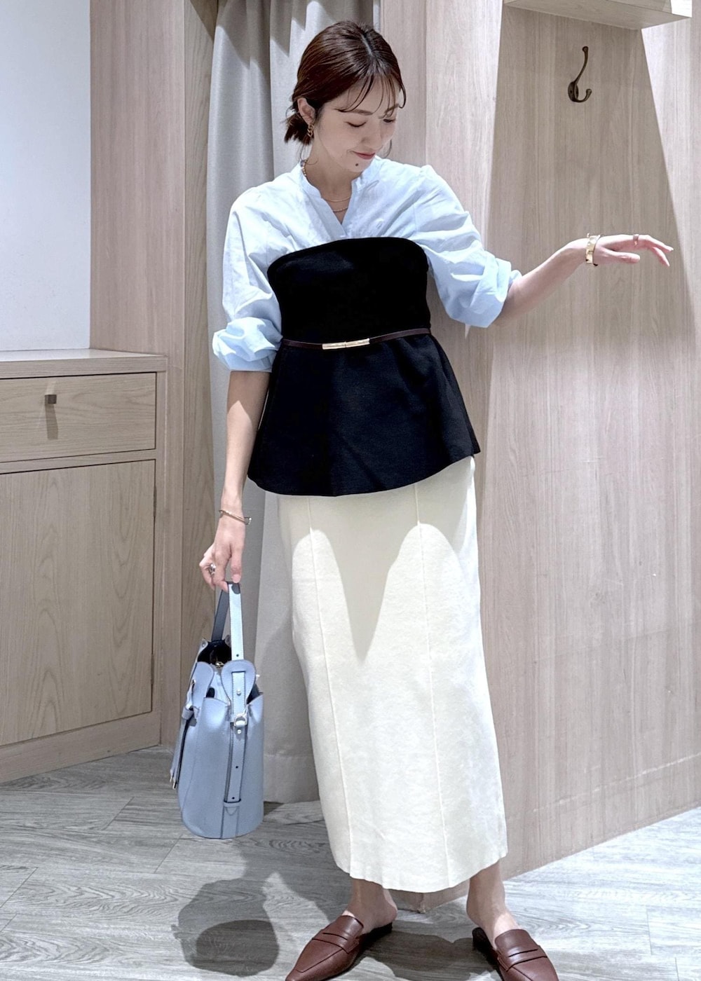 ブルー系のテーラードジャケット、ホワイト系のスカート、ブルー系のショルダーバッグを着用したレディースの春コーディネートの4枚目の写真