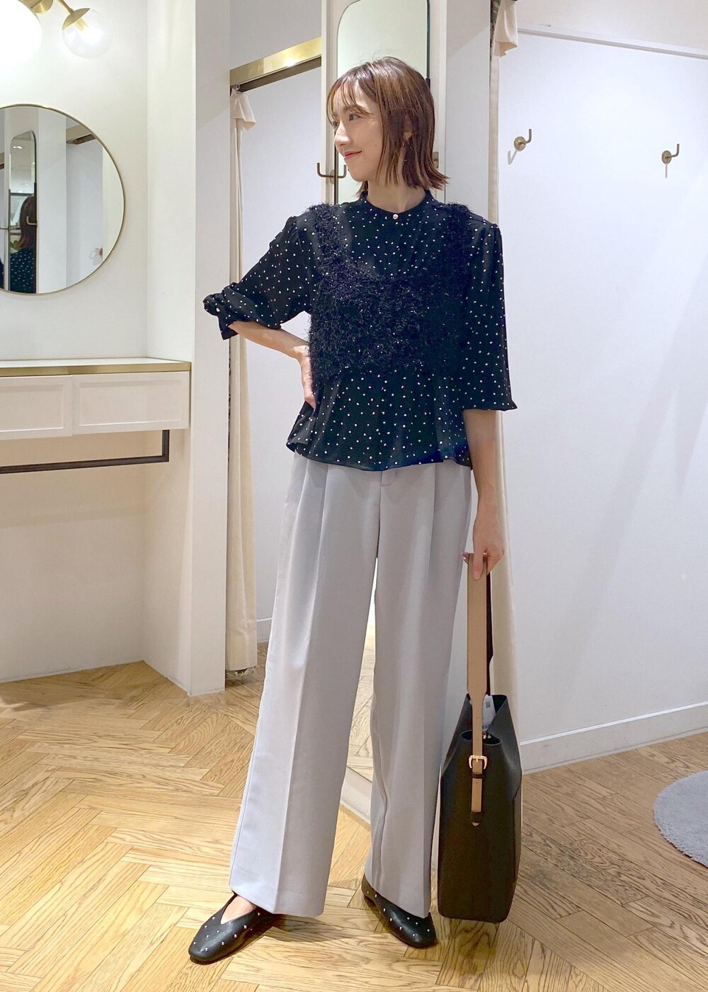 ブラック系のショルダーバッグ、ブラック系のバレエシューズ、ブラック系のキャミソールを着用したレディースの秋コーディネートの4枚目の写真