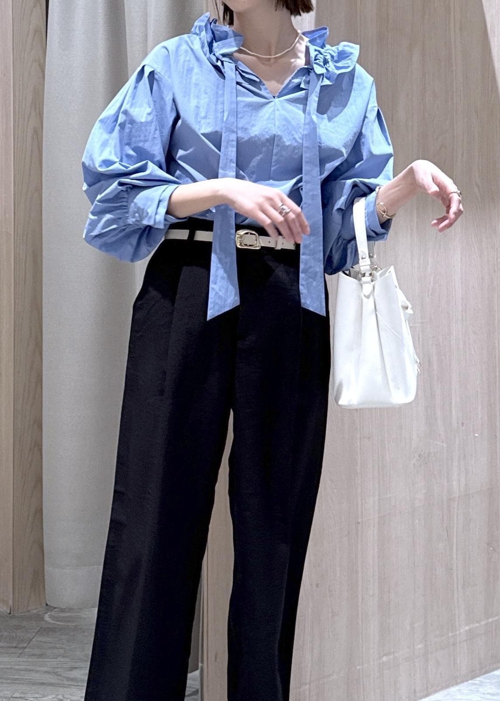 ホワイト系のショルダーバッグ、ブルー系のシャツ/ブラウス、ホワイト系のパンプスを着用したレディースの春コーディネートの4枚目の写真