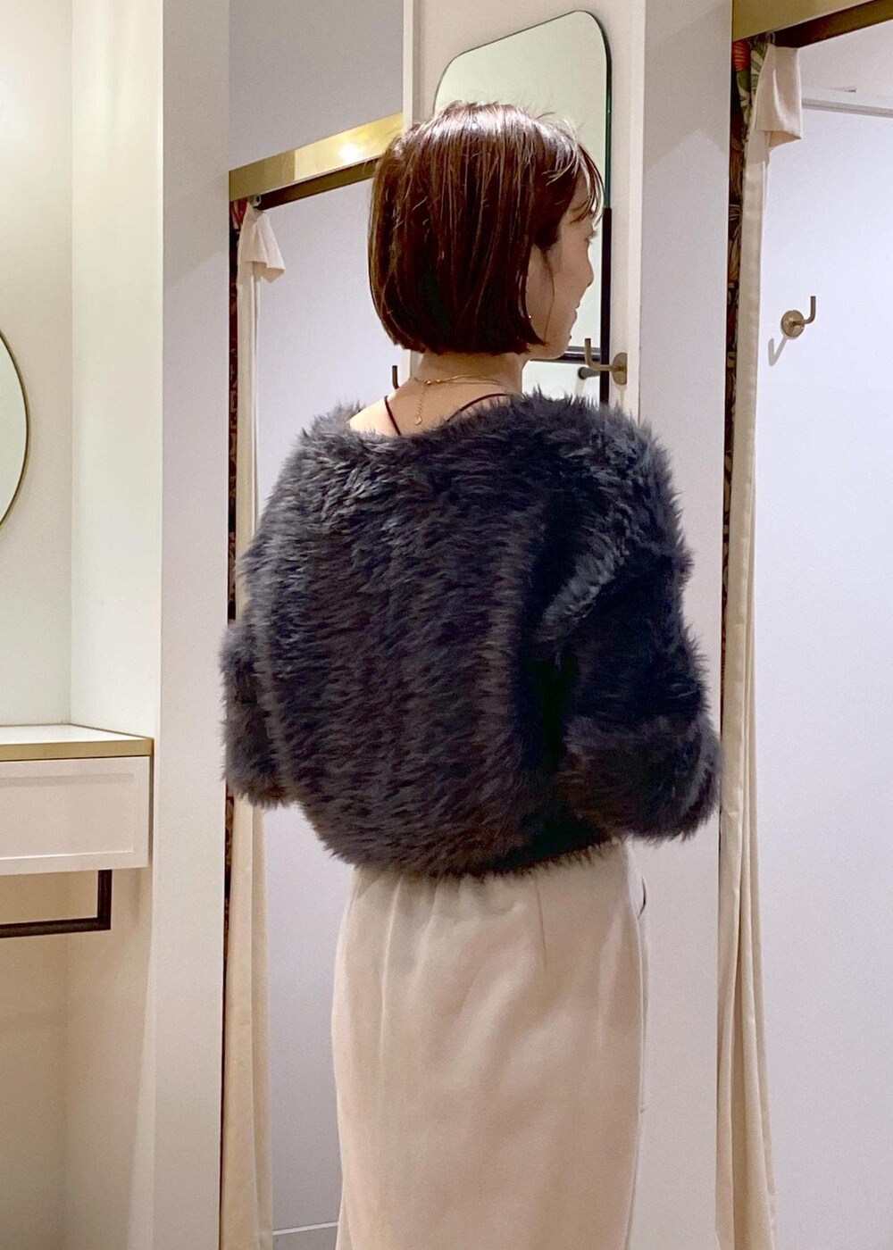 ブラック系のブーツ、ベージュ系のスカート、グレー系のカーディガン/ボレロを着用したレディースの冬コーディネートの8枚目の写真