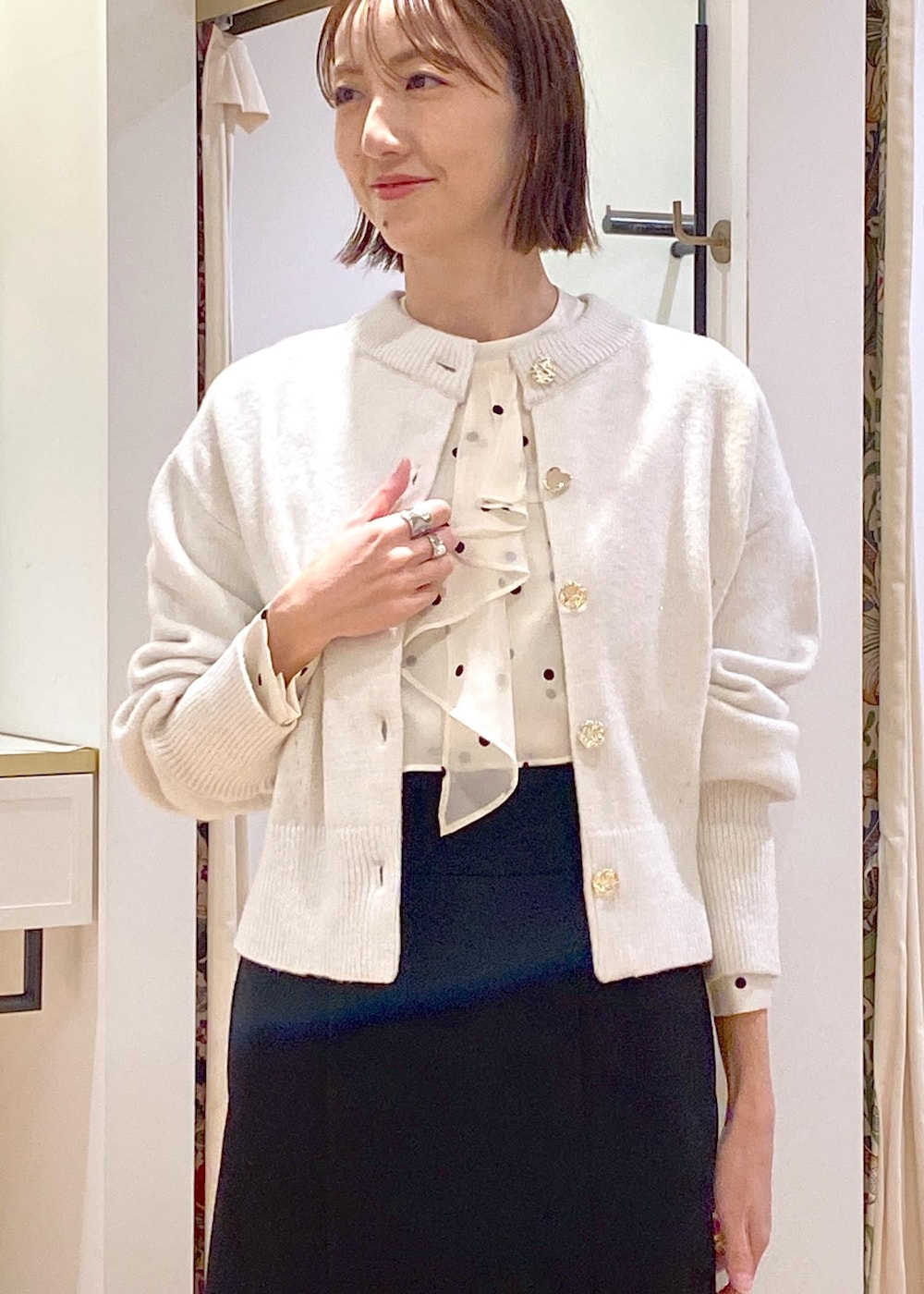 ホワイト系のカーディガン/ボレロ、ブラック系のスカート、ブラック系のパンプスを着用したレディースの冬コーディネートの7枚目の写真