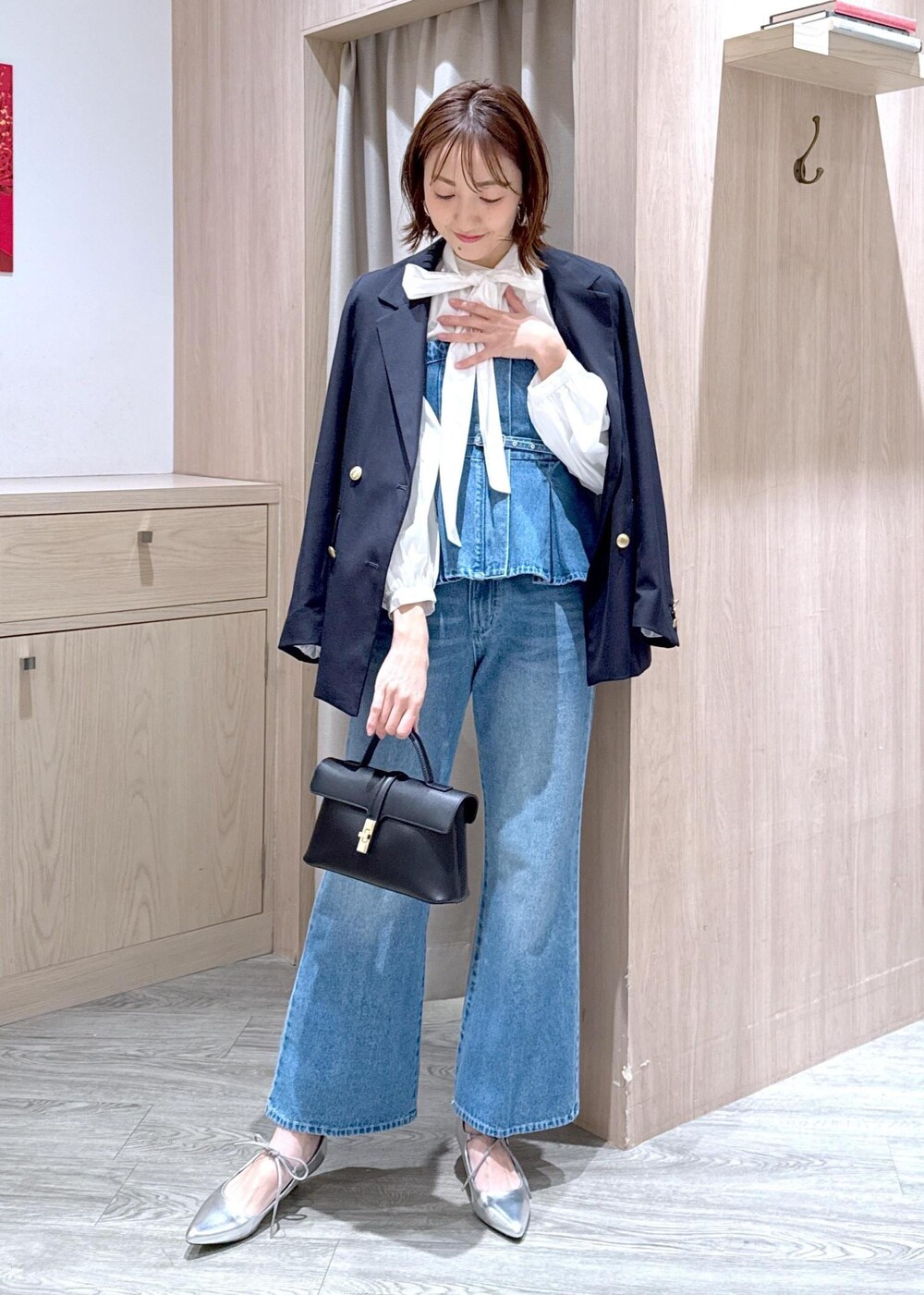 ブラック系のショルダーバッグ、ブルー系のキャミソール、ブルー系のテーラードジャケットを着用したレディースの冬コーディネートの2枚目の写真