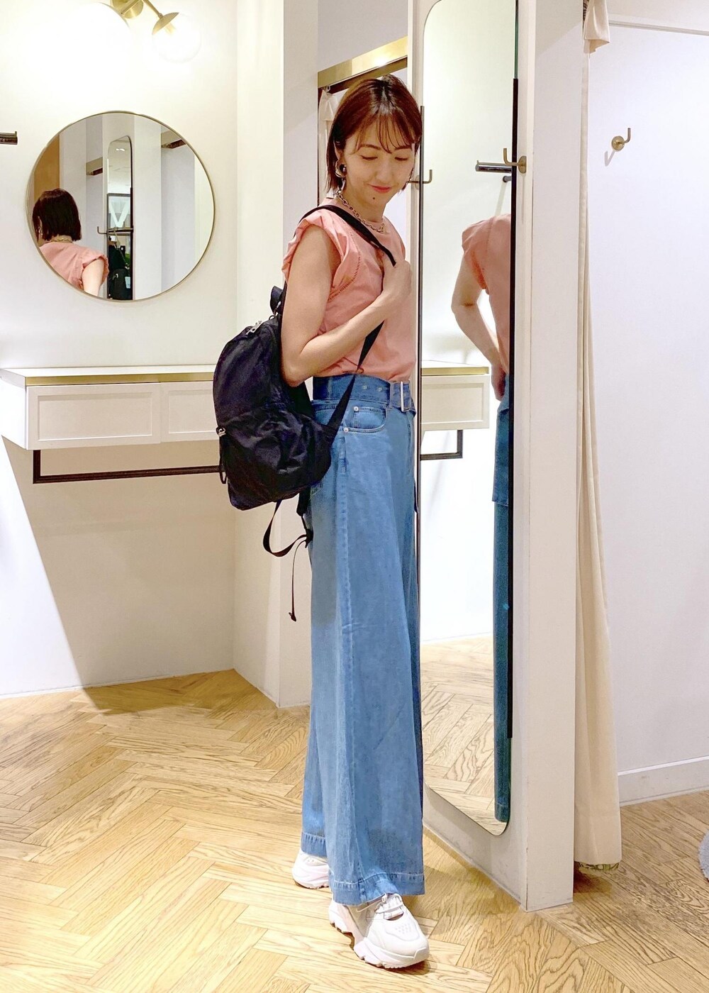 グレー系のスニーカー、ブラック系のバックパック/リュック、ピンク系のTシャツ/カットソーを着用したレディースの春コーディネートの4枚目の写真