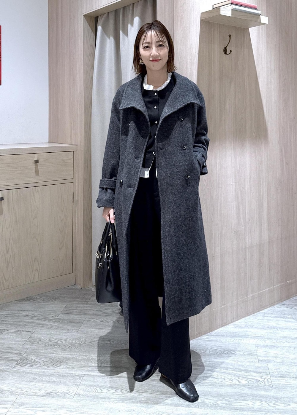 ブラック系のショルダーバッグ、ブラック系のスラックス、グレー系のその他アウターを着用したレディースの冬コーディネートの9枚目の写真