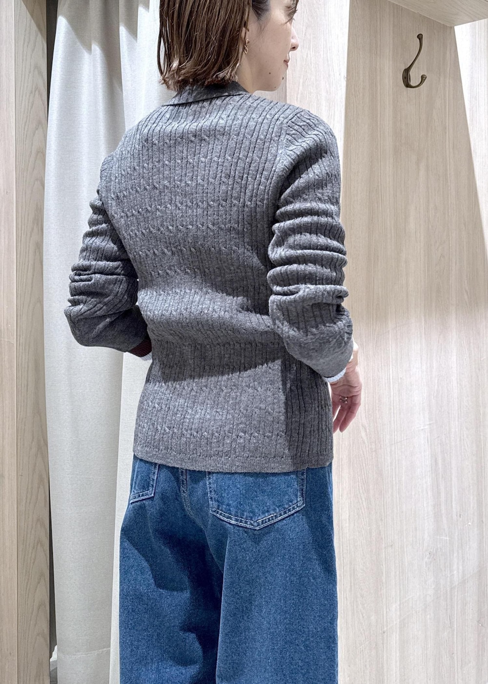 ブラック系のショルダーバッグ、ブルー系のデニムパンツ、グレー系のブルゾンを着用したレディースの冬コーディネートの9枚目の写真