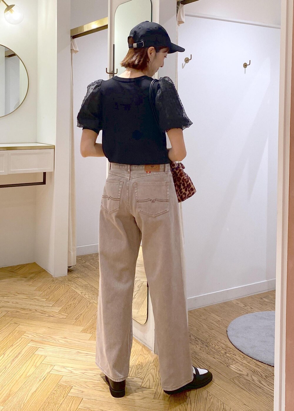 ブラック系のローファー、ブラック系のニット/セーター、ブラウン系のデニムパンツを着用したレディースの夏コーディネートの2枚目の写真