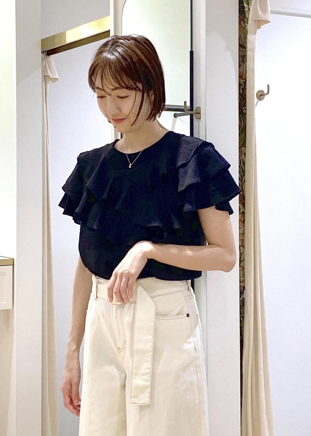 ホワイト系のショルダーバッグ、ブラック系のシャツ/ブラウス、ホワイト系のデニムパンツを着用したレディースの夏コーディネートの5枚目の写真