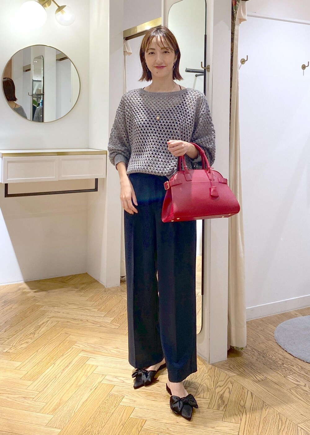 ブルー系のスラックス、ブラック系のサンダル、グレー系のニット/セーターを着用したレディースの秋コーディネートの4枚目の写真